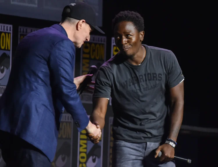 David Jonsson standing alongside Ryan Coogler on the Comic-Con 2026 Hall H stage holding his hand to his chest during the Black Panther 3 announcement.